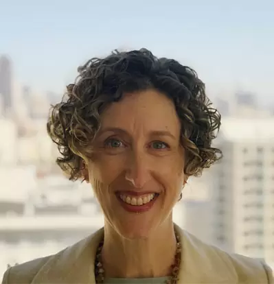 Headshot photo of Polly with San Francisco skyline in the backdrop.